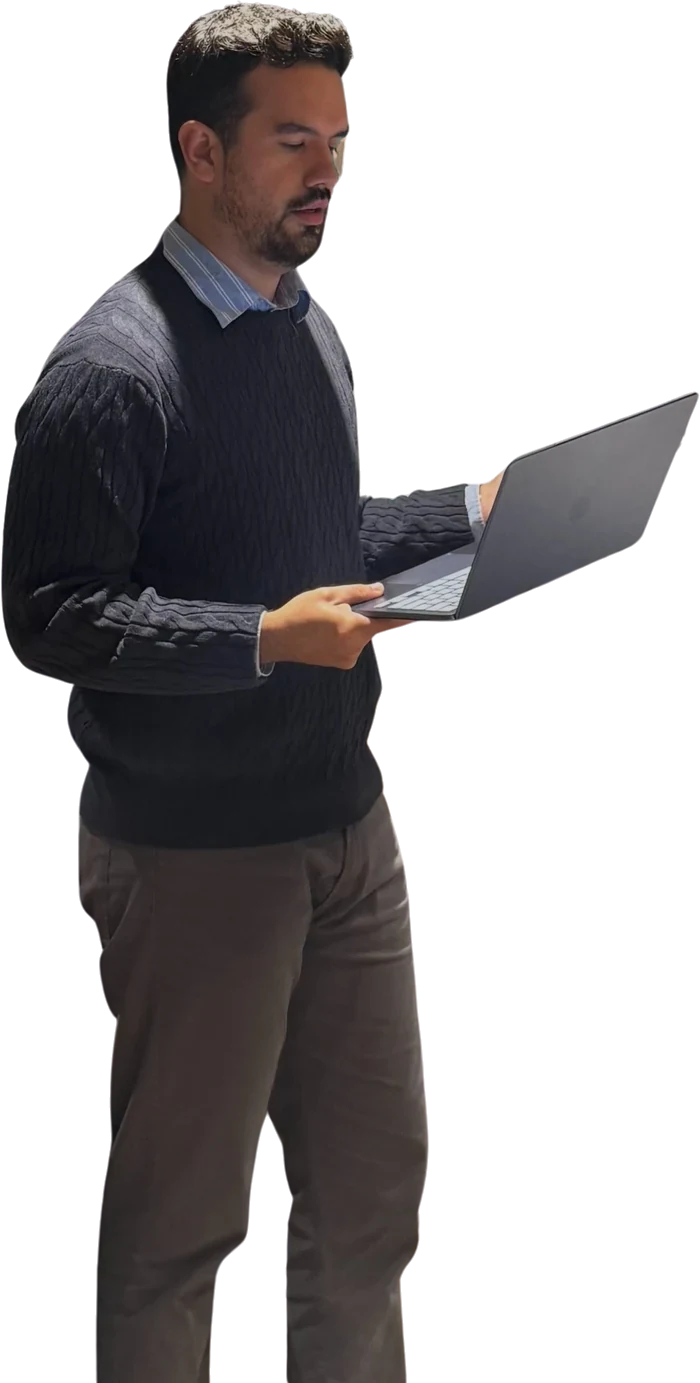 Gabriel de pie revisando un CV en su portátil