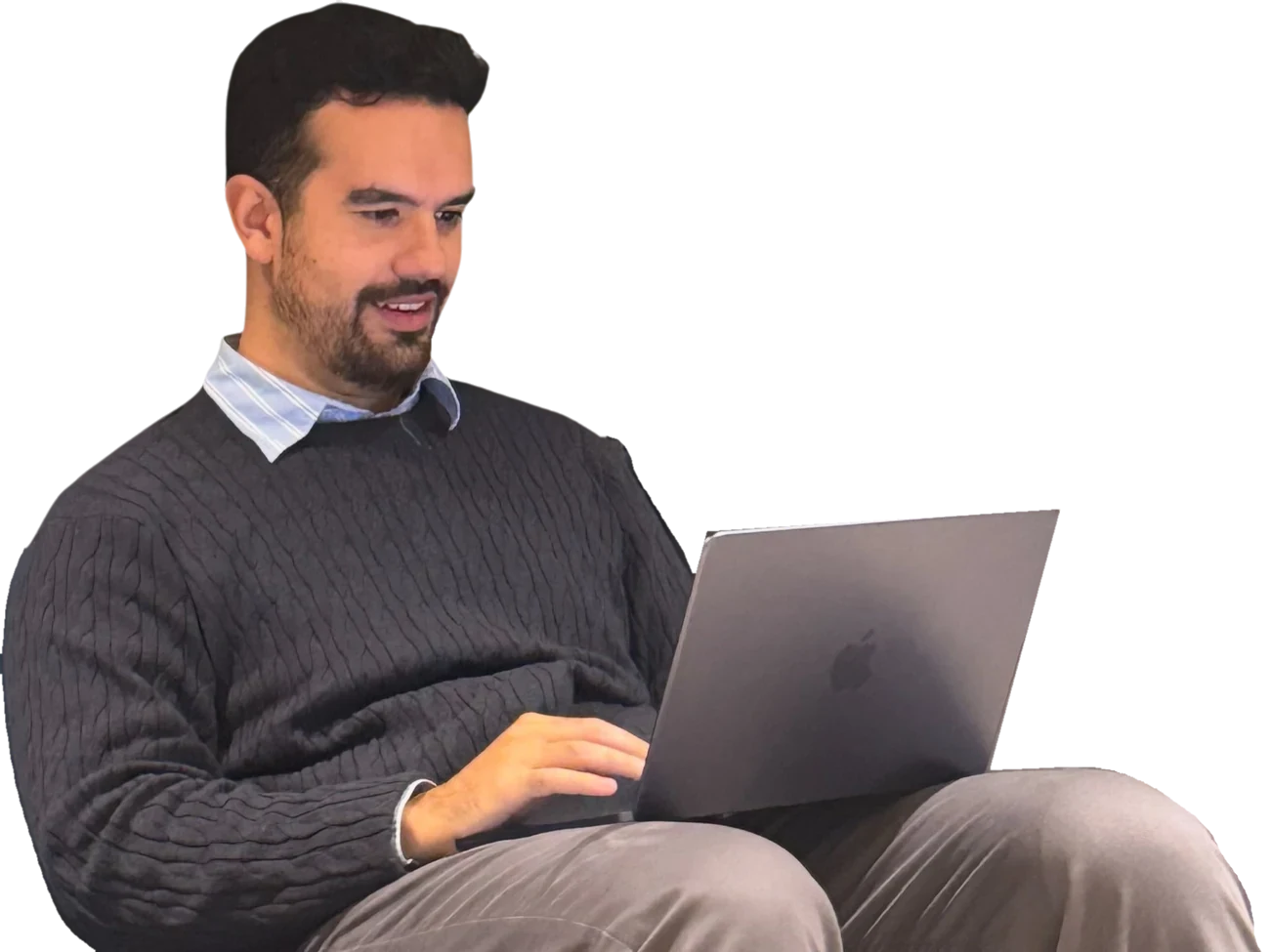 Gabriel sonriendo mientras trabaja en su portátil